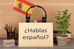 spaans-leren-in-nederland-spaans-taal-leren-spreken-Spaans-Spaanse-vlag-boeken-hoofdtelefoon-potloden